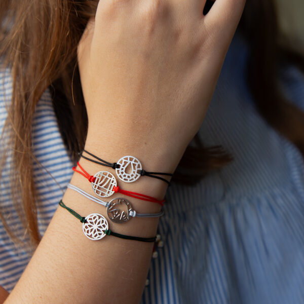 Modelo com motivos, ferradura, sete, andorinha e trevo da pulseira da sorte da coleção good luck da Leitão & Irmão.