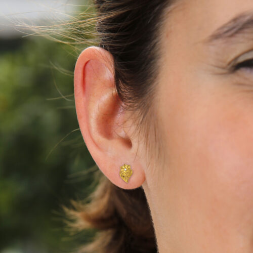 Modelo com par de brincos com coração de filigrana em ouro e diamantes da Leitão & Irmão.